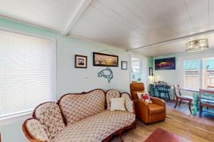 sala de estar con sofá y silla en The Cozy Crab Cottage, en Reedsport