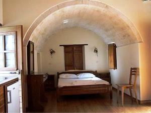 a bedroom with a bed with an archway in it at Lithochtisto in Monemvasia