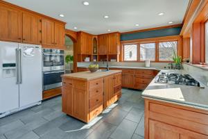 a kitchen with wooden cabinets and a white refrigerator at Large Home with Indoor Basketball Court and Game Room! in Wisconsin Dells