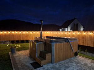 a hot tub with lights on a fence at night at Jelonkowo in Brenna