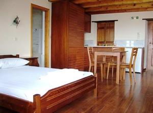 a bedroom with a bed and a kitchen with a table at Lithochtisto in Monemvasia