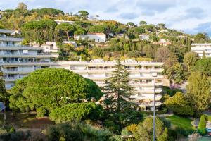 ein Apartmenthaus auf einem Hügel mit Bäumen in der Unterkunft Sur la mer in Cannes