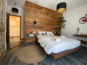 a bedroom with a large bed and a wooden wall at S'accabbadora Guest House in Alghero