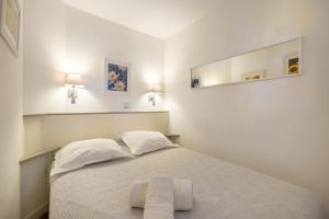 ein Schlafzimmer mit einem Bett, auf dem zwei Handtücher liegen in der Unterkunft Sur la mer in Cannes + 14 Fotos