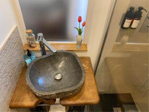a bathroom with a stone sink on a wooden counter at S'accabbadora Guest House in Alghero
