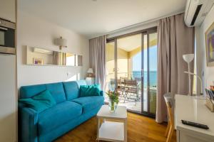 ein Wohnzimmer mit einer blauen Couch und einem Balkon in der Unterkunft Sur la mer in Cannes