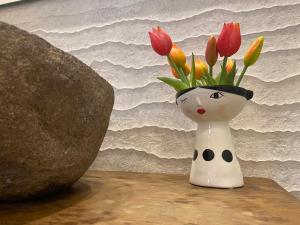 a vase with flowers in it sitting on a table at S'accabbadora Guest House in Alghero