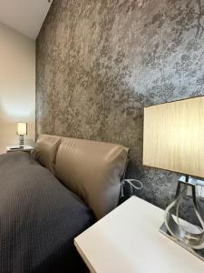 een slaapkamer met een bed en een betonnen muur bij Beatrice Home in Pompei