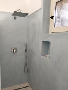 uma casa de banho com chuveiro e cabeça de chuveiro em Dammusielenas em Pantelleria