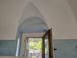 een kamer met een gewelfde deur met een raam bij Dammusielenas in Pantelleria