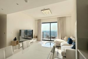 een woonkamer met een bank en een tv bij Luxury 2br In Dubai Hills With Full Park View in Dubai