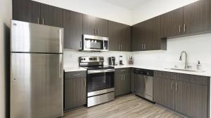 una cocina con electrodomésticos de acero inoxidable y armarios de madera en Landing Modern Apartment with Amazing Amenities (ID9071X06), en San Diego