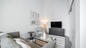 ein Wohnzimmer mit einem Sofa und einem TV in der Unterkunft Landing Modern Apartment with Amazing Amenities (ID9610X26) in Bloomfield