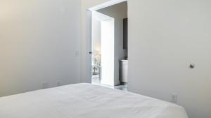 ein Schlafzimmer mit weißen Wänden und einem weißen Bett in der Unterkunft Landing Modern Apartment with Amazing Amenities (ID9610X26) in Bloomfield