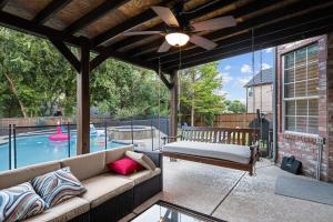 a patio with a couch and a ceiling fan at Heated Pool PoolTable HotTub Sleeps 16 Renovated in McKinney