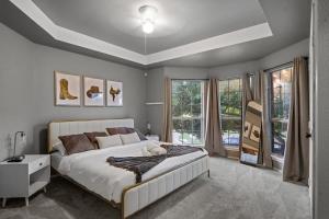 a bedroom with a large white bed and windows at Heated Pool PoolTable HotTub Sleeps 16 Renovated in McKinney