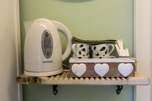 a white mixer sitting on a shelf with mugs at Casa Montalgallo in Lucignano