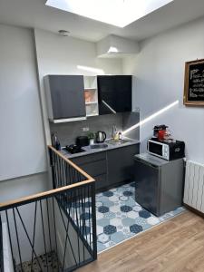 een keuken met een wastafel en een fornuis bij Chambre cozy proche Paris/CDG in Le Blanc-Mesnil