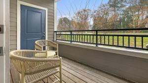 une véranda avec une chaise, une porte bleue et une fenêtre dans l'établissement Landing Modern Apartment with Amazing Amenities (ID1012X377), à Wake Forest