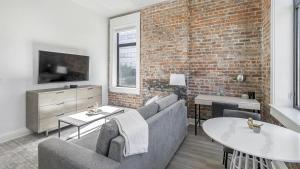 salon z kanapą i ceglaną ścianą w obiekcie Landing - Modern Apartment with Amazing Amenities (ID5790X40) w mieście Birmingham
