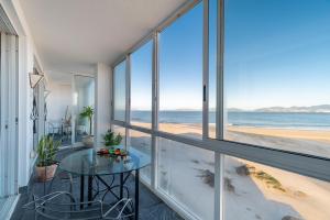 a room with a table and a view of the beach at El Balcón de Samil in Vigo