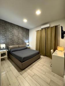 1 dormitorio con cama, mesa y escritorio en Beatrice Home en Pompei