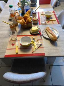 un tavolo con cibo e pane sopra di esso di Chambre privée dans maison + petit déjeuner offert a Saint-Priest