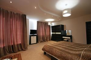 1 dormitorio con cama, TV y cortinas en Mini hotel in Observatorniy, en Odessa