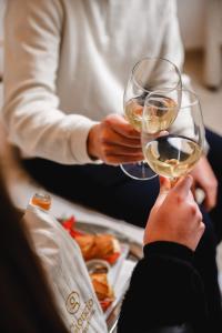a person holding a glass of white wine at Giorgio Boutique Hotel in Sliema