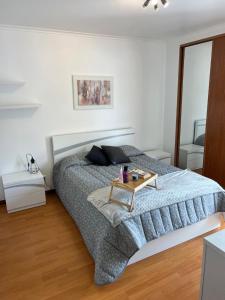 a bedroom with a bed with a table on it at Populo Beach Villa, Walk to Beach, Air Conditioning and Heating, near Ponta Delgada in Livramento