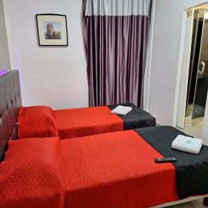 two beds in a room with red and black at Hostal Africa Do Sul in Lisbon