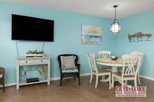 uma sala de jantar com uma mesa e uma televisão na parede em Sea Breeze 305 em Gulf Shores