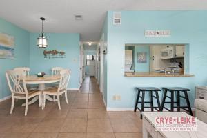 a dining room and kitchen with a table and chairs at Sea Breeze 305 in Gulf Shores