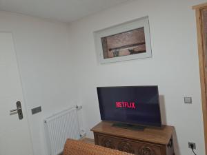 Une télévision à écran plat est installée au-dessus d'une table en bois. dans l'établissement Ferienwohnung Anna, à Schramberg