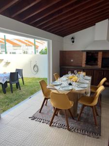 comedor con mesa y sillas y patio en Populo Beach Villa, en Livramento