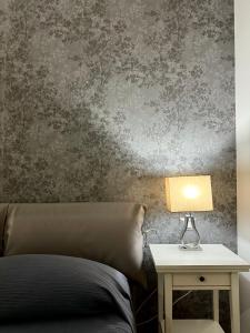 een slaapkamer met een bed en een tafel met een lamp bij Beatrice Home in Pompei
