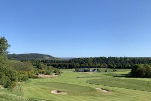 uma vista para um campo de golfe com dois putting greens em The Delnashaugh em Ballindalloch