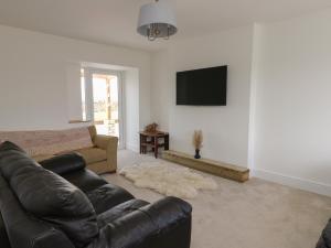 sala de estar con sofá y TV de pantalla plana en Haulfryn en Holyhead