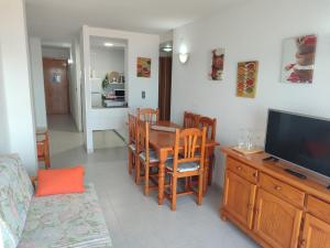 a living room with a dining room table and a television at Apartamentos Forner in Peniscola