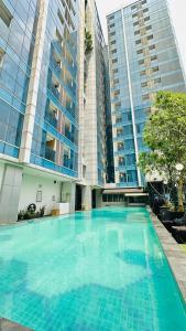 a large swimming pool in front of some tall buildings at Tamansari Hive Cawang by Villaloka in Jakarta