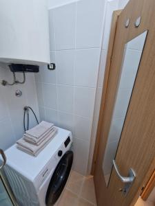 een wasmachine in de badkamer met een spiegel bij Apartment Lea in Ližnjan