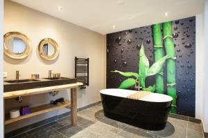 La salle de bains est pourvue d'une baignoire noire et d'un lavabo. dans l'établissement BijJoop, à Kalenberg