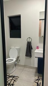 La salle de bains blanche est pourvue de toilettes et d'un lavabo. dans l'établissement The Blyde Crystal Lagoon Luxury Stays, à Pretoria
