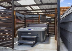 a hot tub sitting under a wooden pergola at Hill Farm Retreat in Wangford