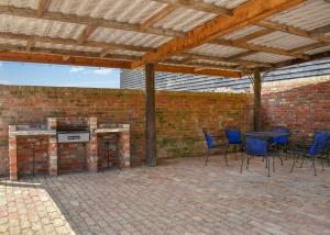 a patio with a table and chairs and a brick wall at Hill Farm Retreat in Wangford