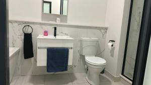 a white bathroom with a toilet and a sink at The Blyde Crystal Lagoon Luxury Stays in Pretoria