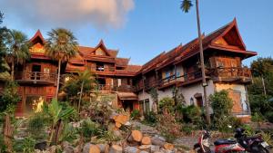 a house with a motorcycle parked in front of it at Orchid Home in Ko Tao