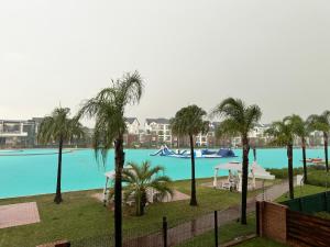 Elle offre une vue sur une grande piscine bordée de palmiers. dans l'établissement The Blyde Crystal Lagoon Luxury Stays, à Pretoria