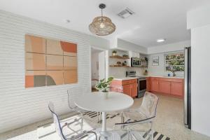 a kitchen with red cabinets and a white table and chairs at SoFlo Oasis 6 min to Beach Pool BBQ in Fort Lauderdale