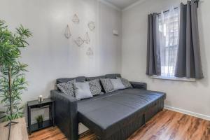 ein Wohnzimmer mit einem Sofa und einem Fenster in der Unterkunft TWO Modern Apartment Minutes to NYC in Jersey City